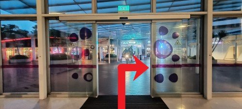 Go through the Exit. Turn right and walk to the sheltered walkway.